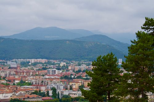 Free Aerial photo of an Italian city framed by green hills and cloudy skies. Stock Photo