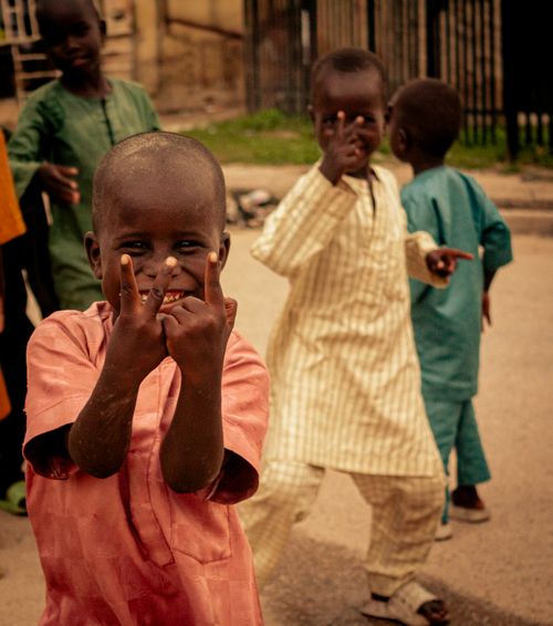 Free Smiling children enjoying playful moments outside in traditional attire, captured during daytime. Stock Photo