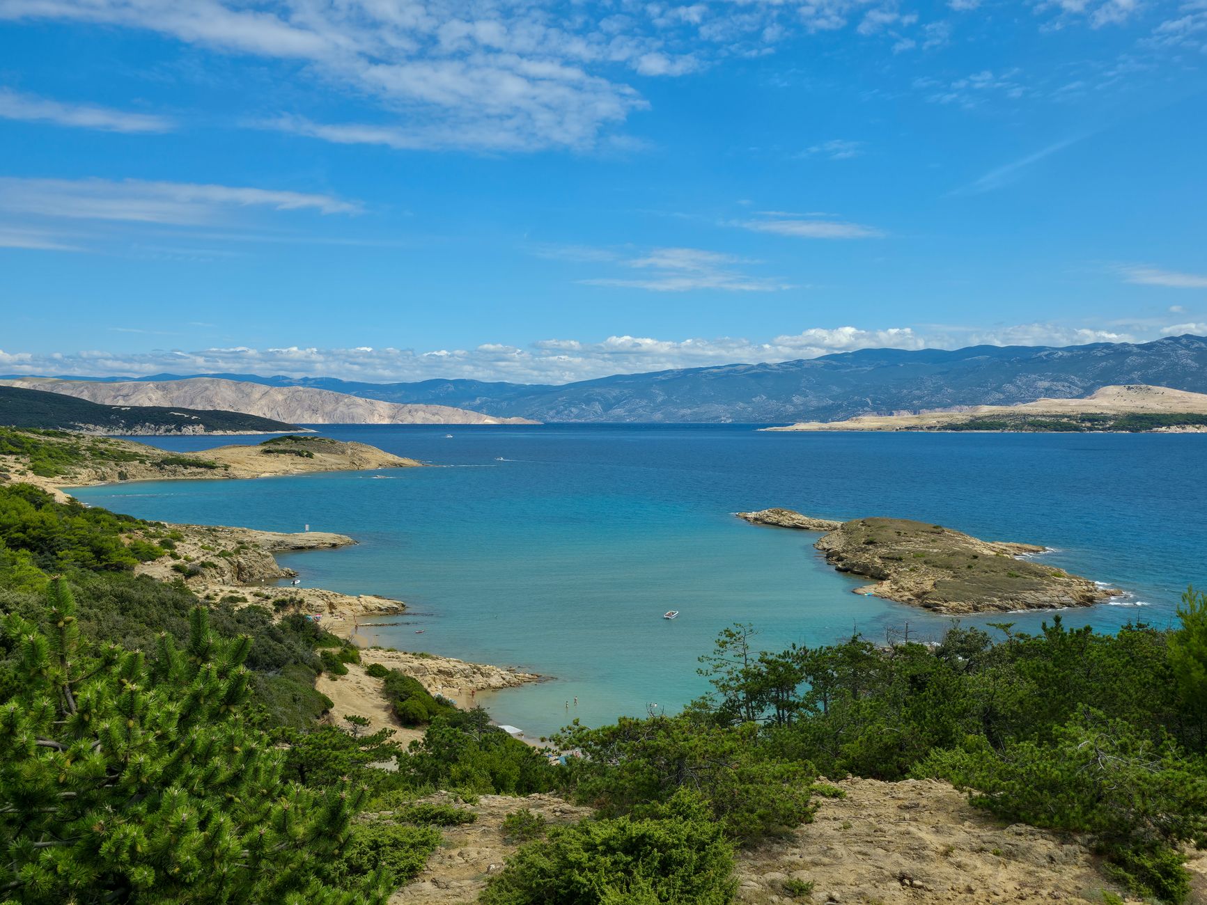 Beautiful coastal view showcasing crystal clear blue waters and rugged landscape.
