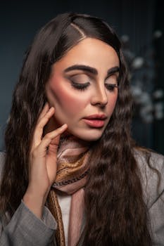 Sophisticated portrait of a woman showcasing elegant fashion and makeup in a studio setting.