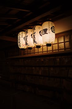 Ethereal glow of traditional Japanese lanterns illuminating the night in Kyoto's historic district.