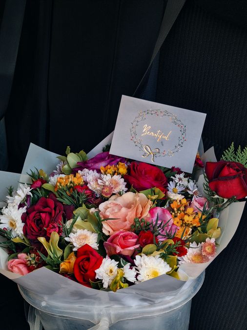 Bouquet of mixed flowers with a handwritten quote card