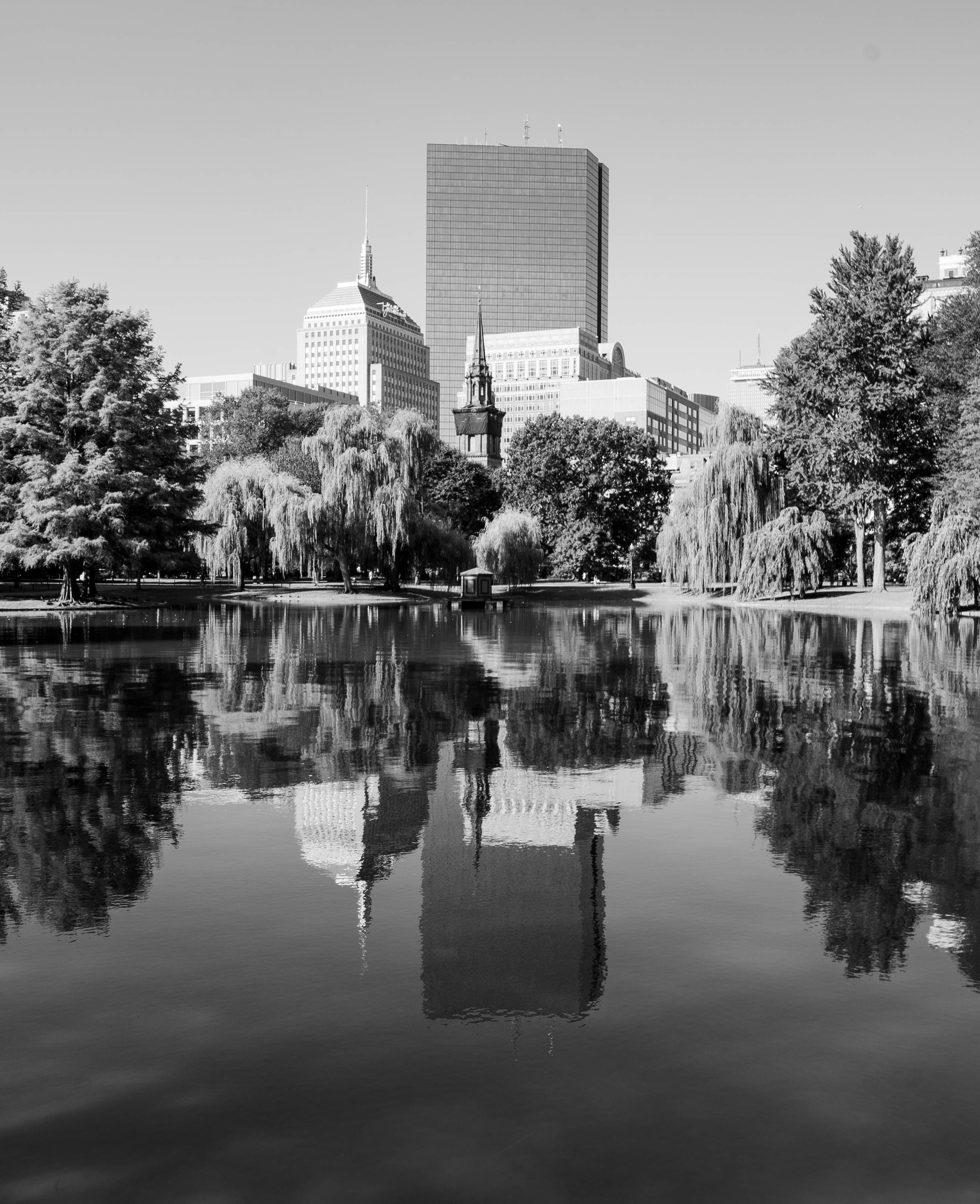 Gratis Et klassisk sort-hvidt bybillede af Boston med refleksioner af byens skyline i en fredfyldt dam. Lagerfoto