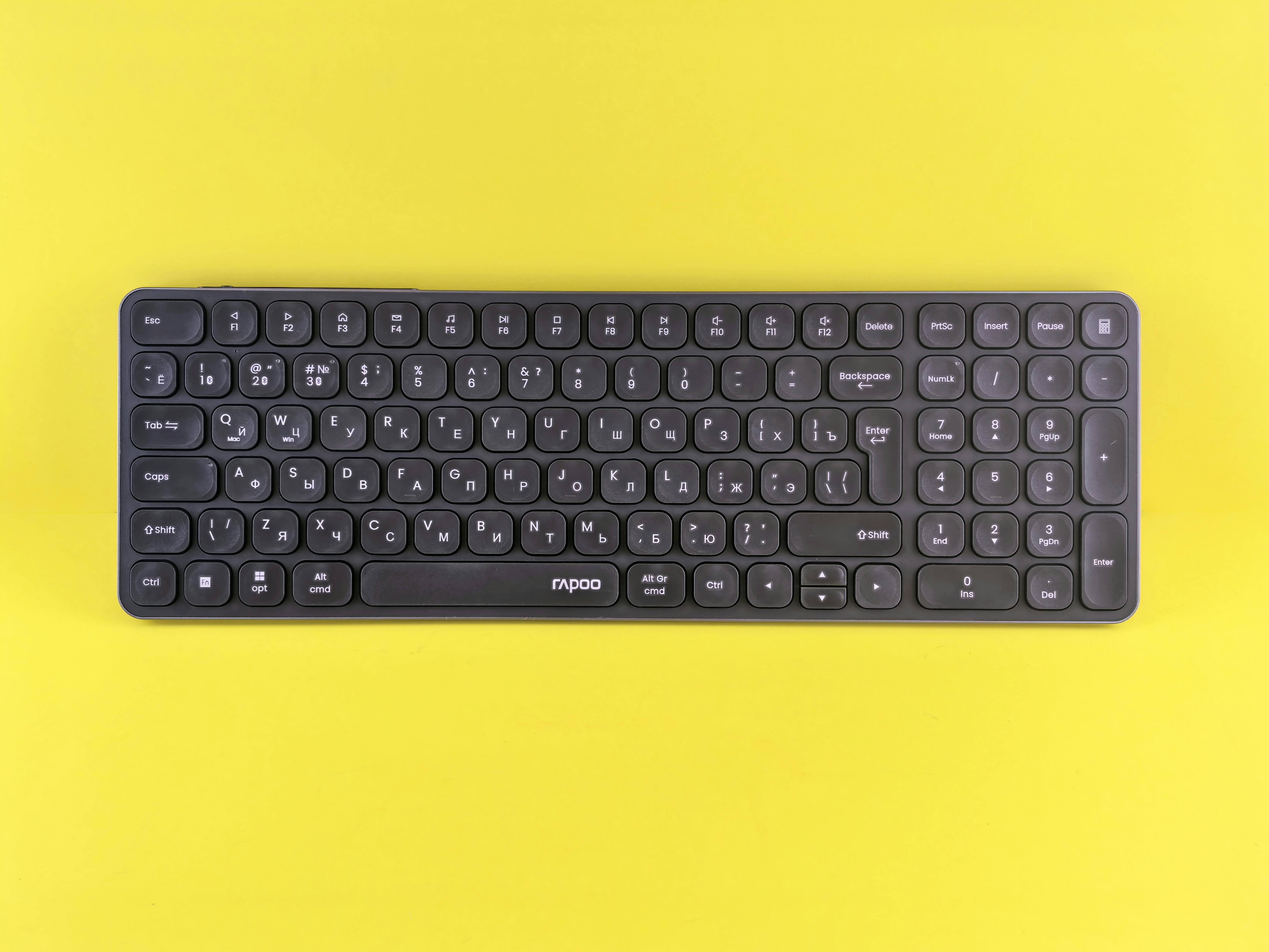 A sleek black wireless keyboard displayed against a vibrant yellow background, perfect for tech themes.