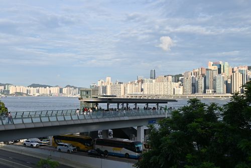 Free Urban skyline by the water with pedestrian bridge and busy traffic below. Stock Photo