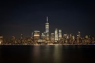 夜晚，纽约市灯火辉煌的天际线倒映在海滨，令人叹为观止