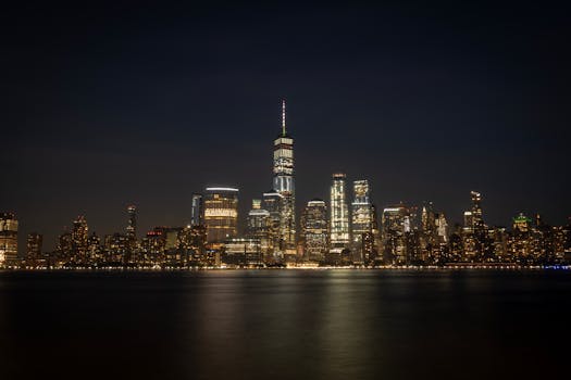 夜晚，纽约市灯火辉煌的天际线倒映在海滨，令人叹为观止