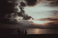 Silhouette of people seated during a dramatic sunset in Bantayan, Philippines.