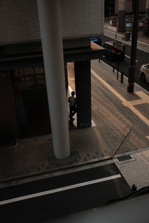 Free Moody cityscape showing a person walking along an urban street at twilight. Stock Photo