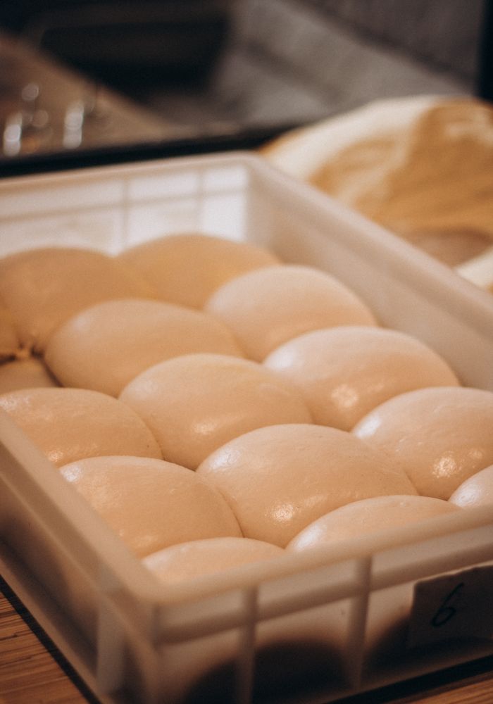 Panetti di impasto allineati in una cassetta di lievitazione