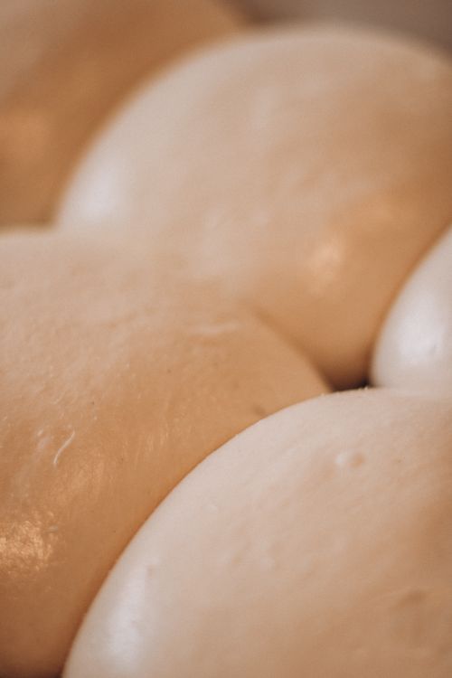 Free Macro shot of smooth, rising dough balls on a tray, showcasing texture and preparation. Stock Photo