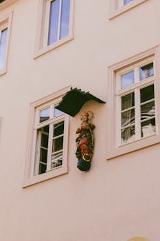 Elegant architectural facade in Kassel, featuring a religious statue, evoking urban life and history.