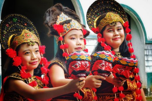 Indonesian dancers in vibrant traditional attire and masks, showcasing cultural heritage.