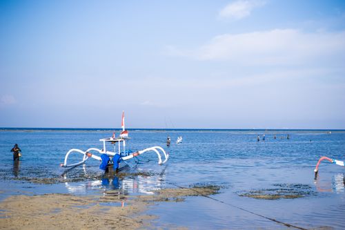 Free Serene image of a traditional boat on a beautiful Bali beach during a sunny day. Stock Photo