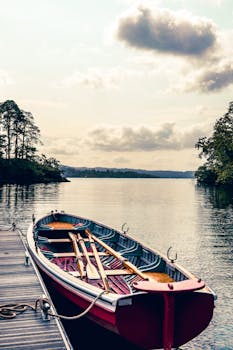 Peaceful scene of a vintage rowboat moored on Brathay Lake in tranquil rural England.