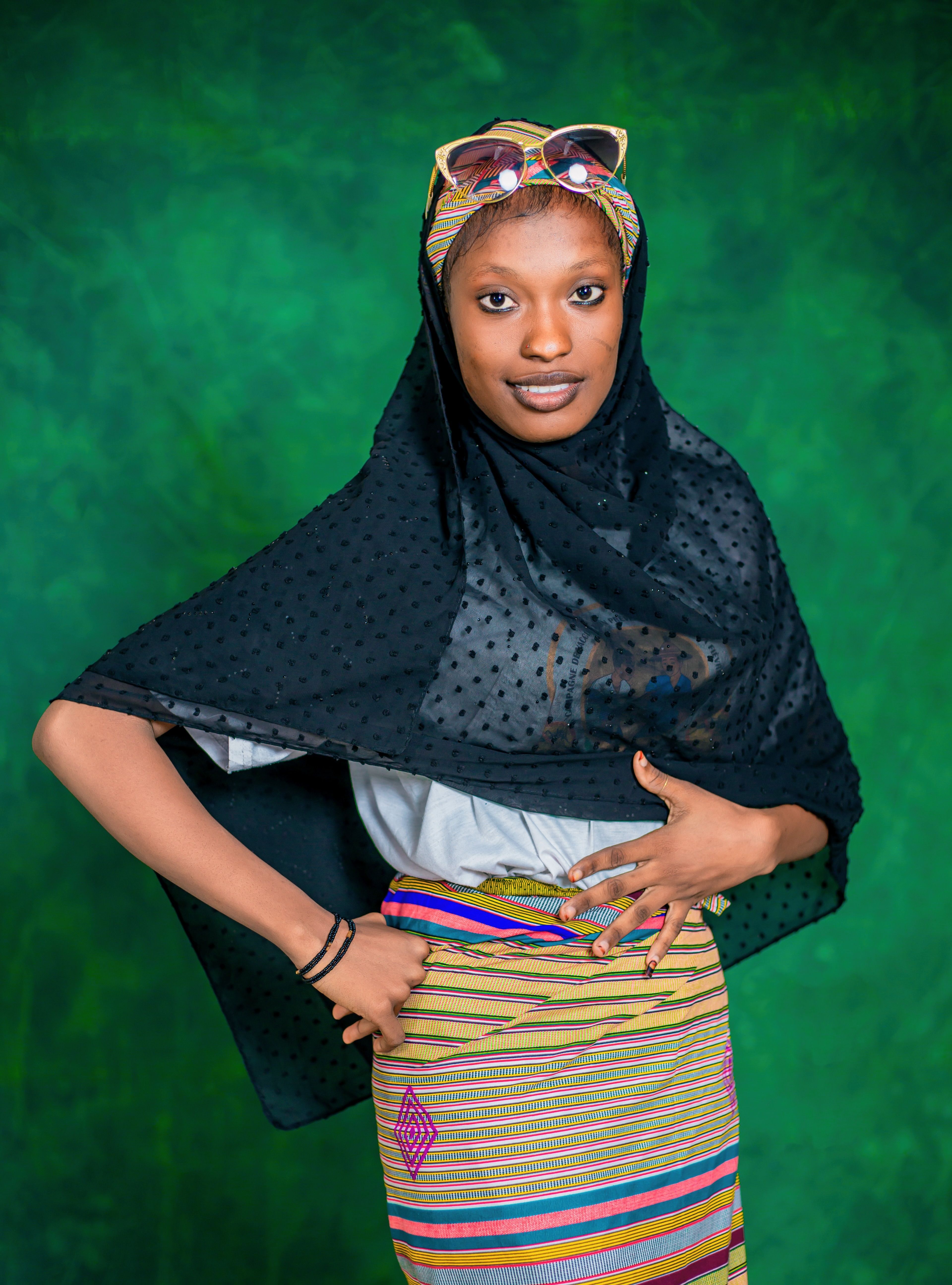 Confident woman in colorful traditional wear posing indoors.