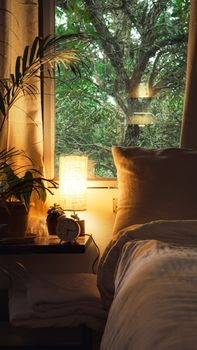 A serene bedroom setting with a lush forest view through the window, perfect for relaxing stays in Madikeri, India.