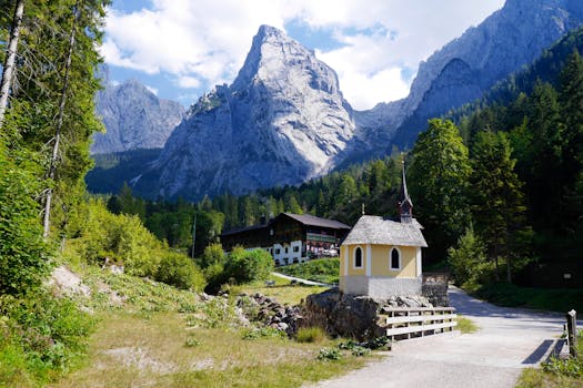 在明亮的天空下，奥地利蒂罗尔库夫斯坦的教堂与山脉构成了一幅田园诗般的景色