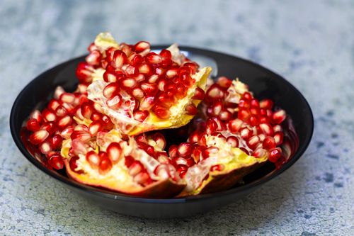 Free Close-up of fresh pomegranate seeds in a black bowl, showcasing vibrant colors and textures. Stock Photo
