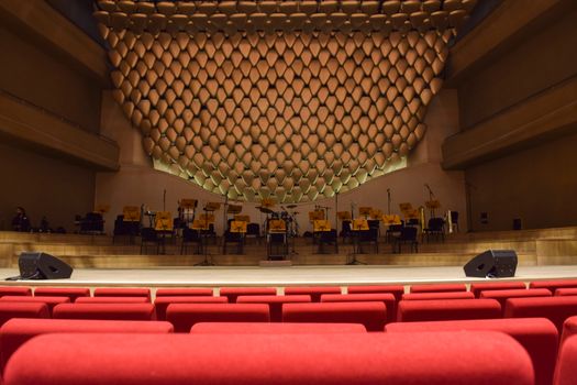 Elegant concert hall interior with empty seats and stage, ready for performance.