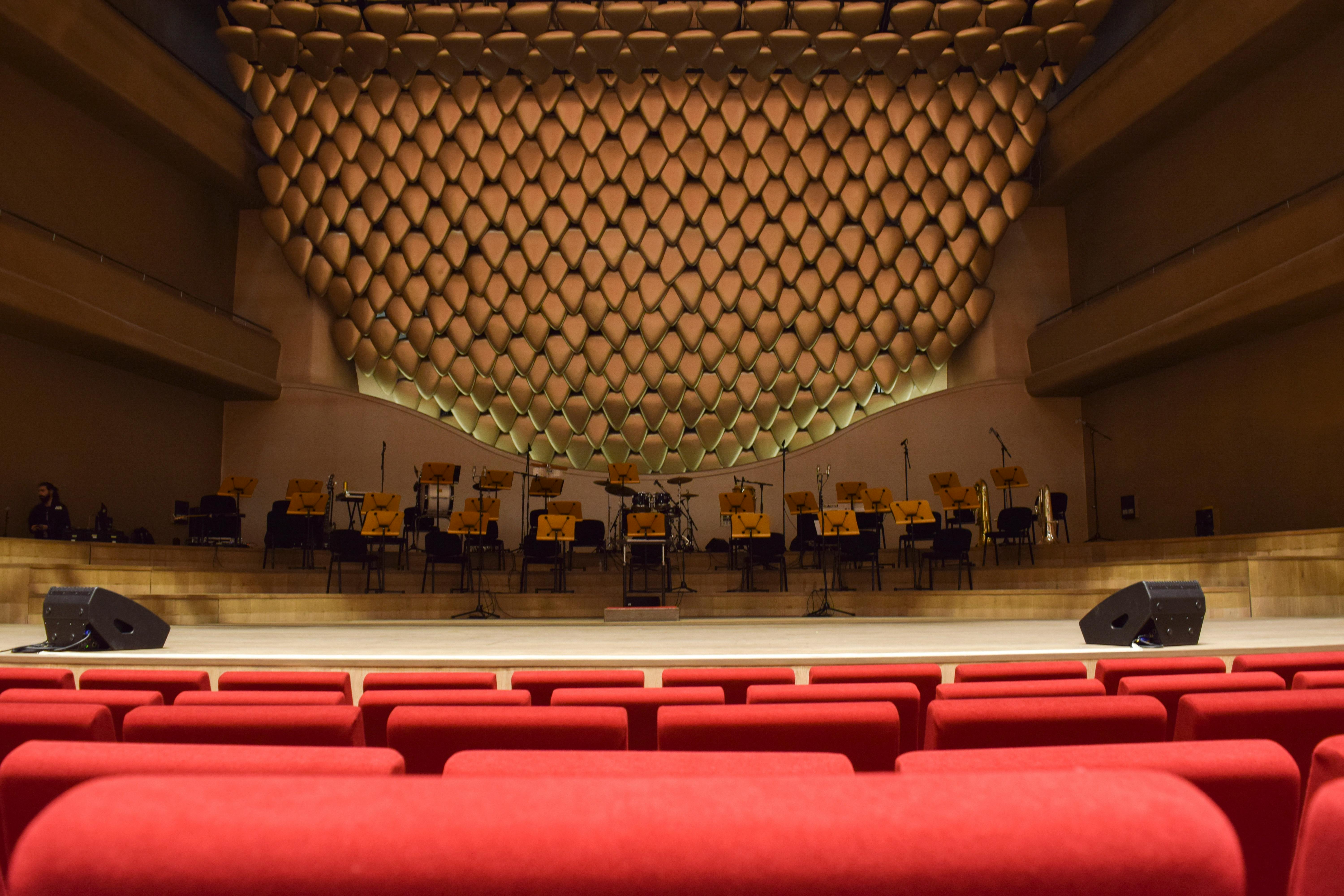 gratis Elegant concertzaalinterieur met lege stoelen en podium, klaar voor een optreden. Stockfoto