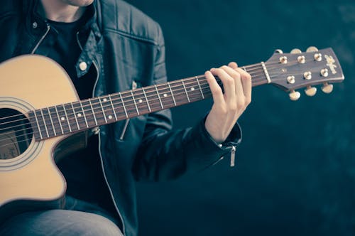Free Person Holding Brown and Black Guitar Stock Photo