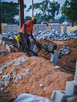 Local workers at a construction site handling bricks and materials in Kaduna, Nigeria.