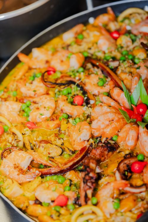 Free Delicious seafood paella loaded with shrimps, peas, and spices. Perfect for a gourmet culinary experience. Stock Photo