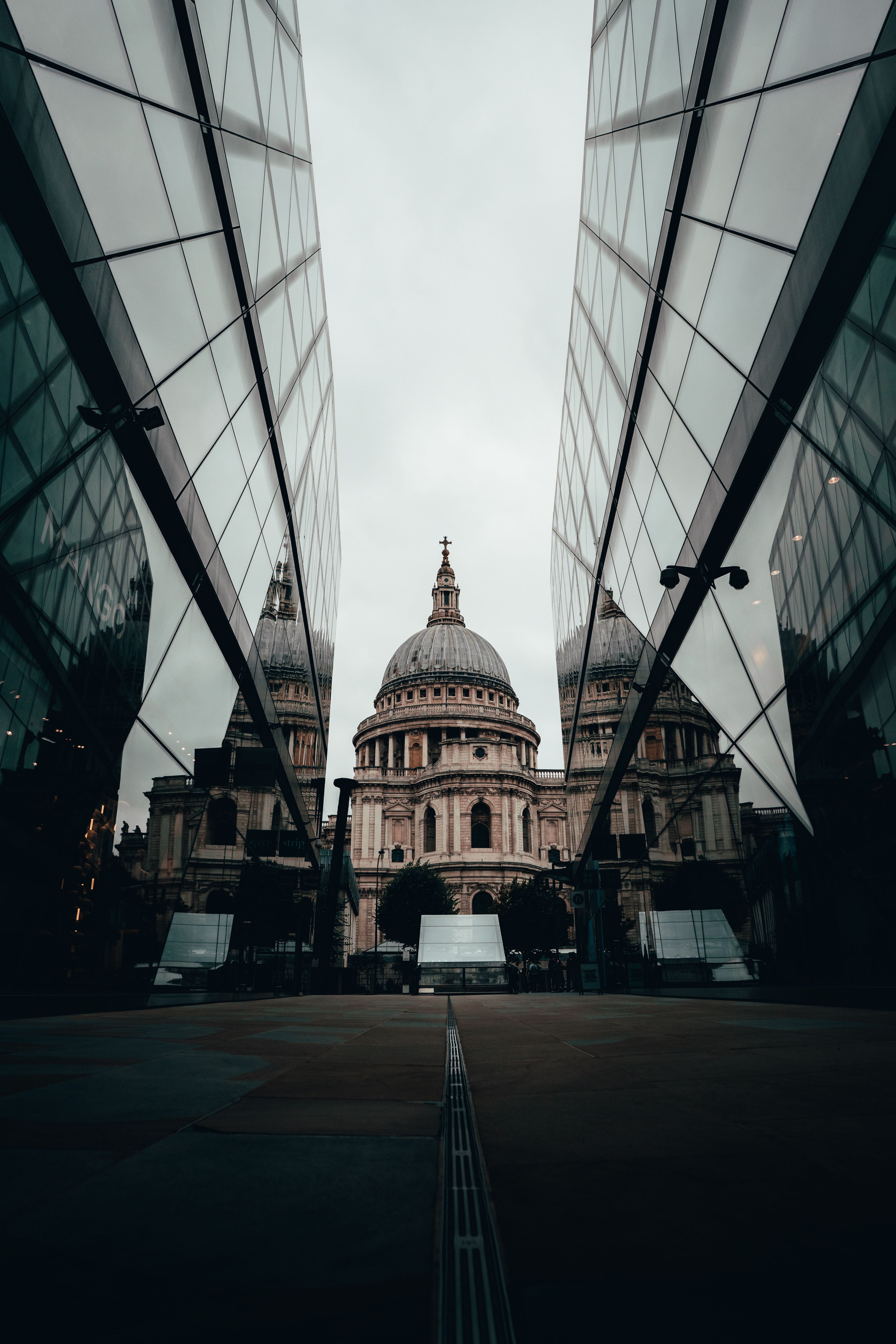 View of St. Paul's Cathedral framed by reflective modern architecture in London, England.