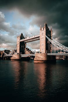 Stunning twilight capture of Tower Bridge with moody clouds in London, UK.