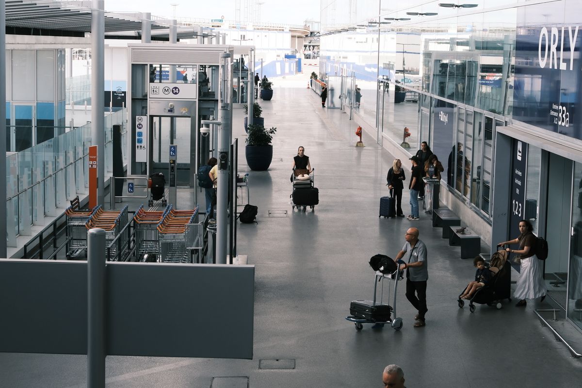 Passengers with suitcases in an airport terminal corridor