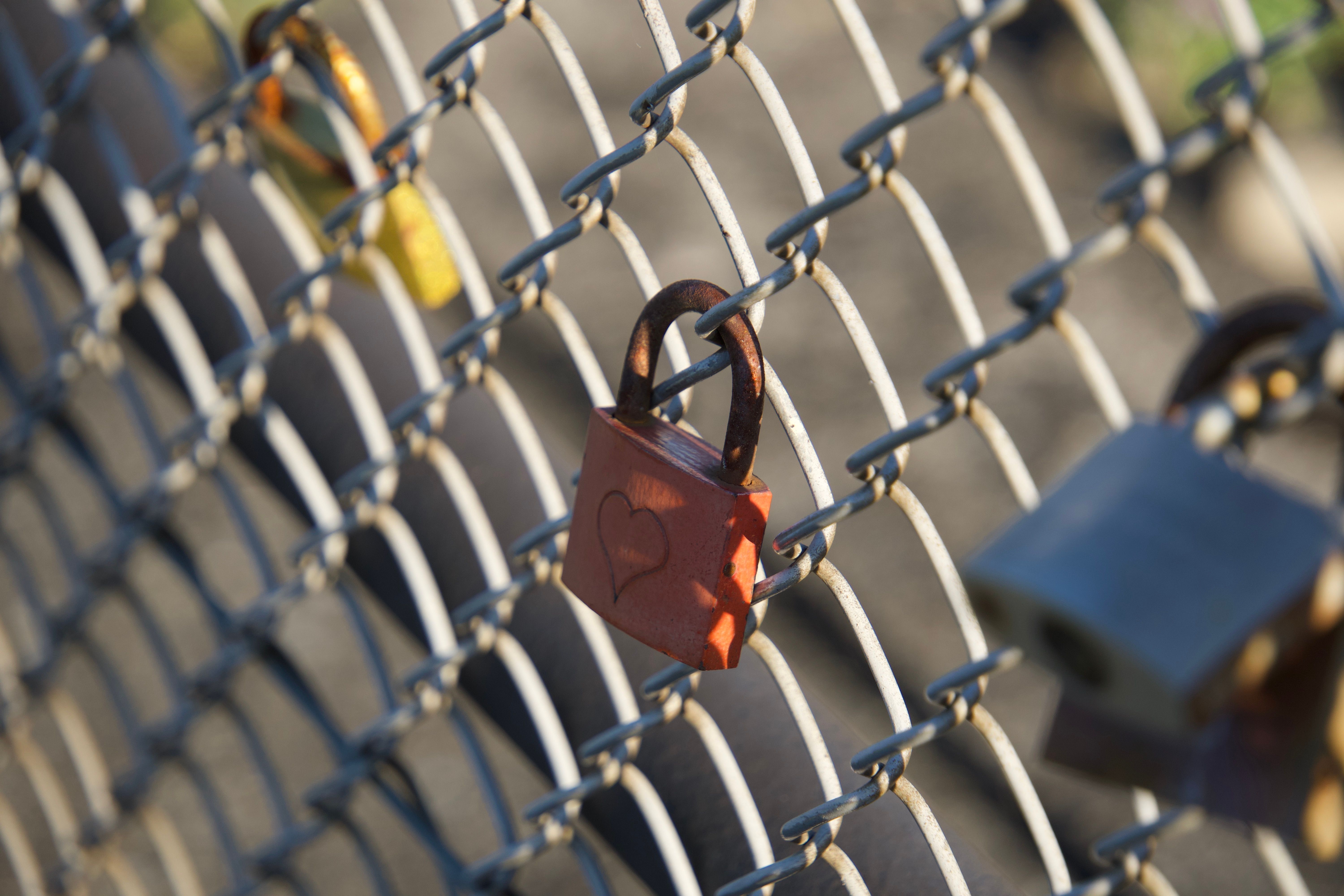 Gros plan d'un cadenas en forme de cœur sur une clôture grillagée à Neuhausen am Rheinfall, en Suisse.