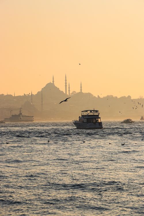 Free Boat sailing at sunset with Istanbul's iconic skyline in the background. Stock Photo