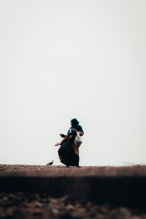 Free A solitary woman walks along a foggy Brighton beach in winter, evoking a sense of solitude. Stock Photo