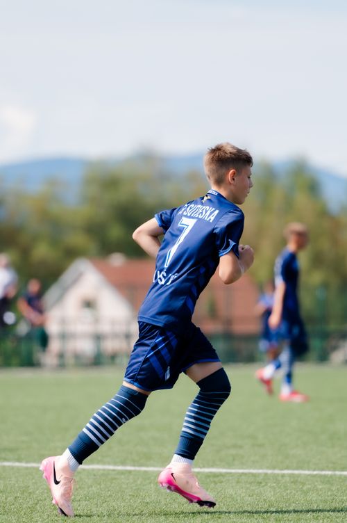 Free Boy in blue soccer uniform running during a game on a clear day. Stock Photo