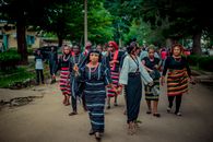 Group in colorful traditional clothing walking in a lively outdoor cultural parade.