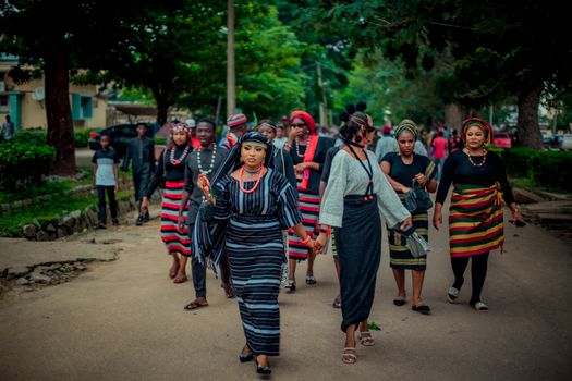 Group in colorful traditional clothing walking in a lively outdoor cultural parade.