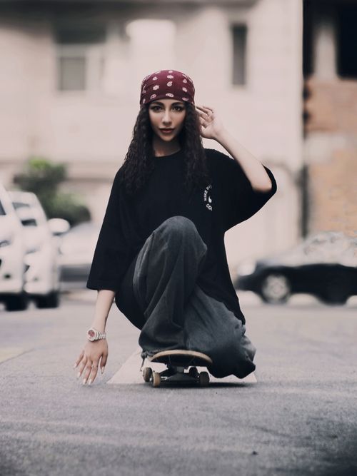 Free Young woman skateboarding in a city street, showcasing urban fashion style. Stock Photo