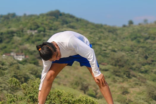 Man practicing yoga outdoors in the scenic hills of Huehuetla, Puebla, Mexico with a focus on well-being.