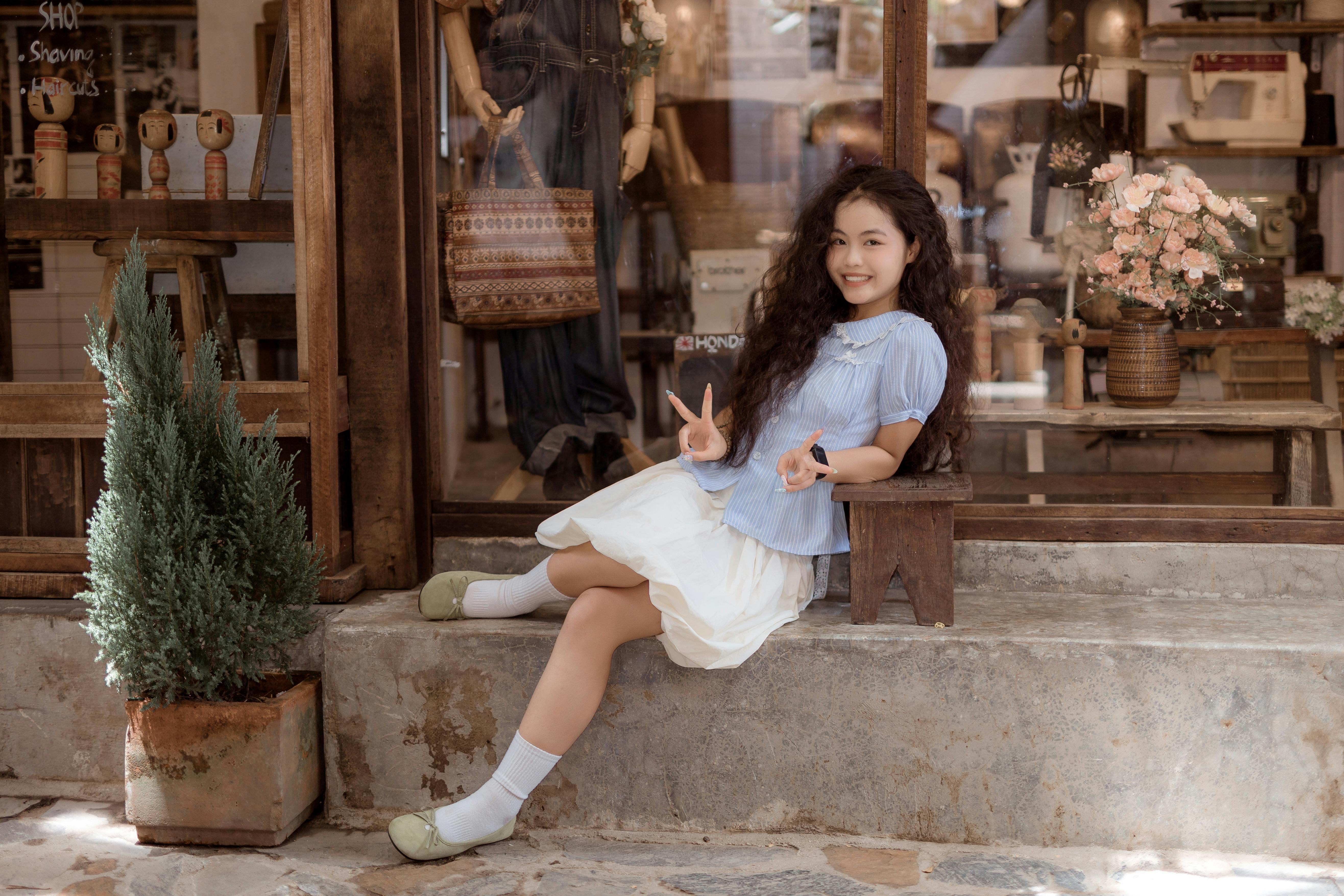 Mutlu bir kadın uluslararası bir vitrinin önünde poz veriyor