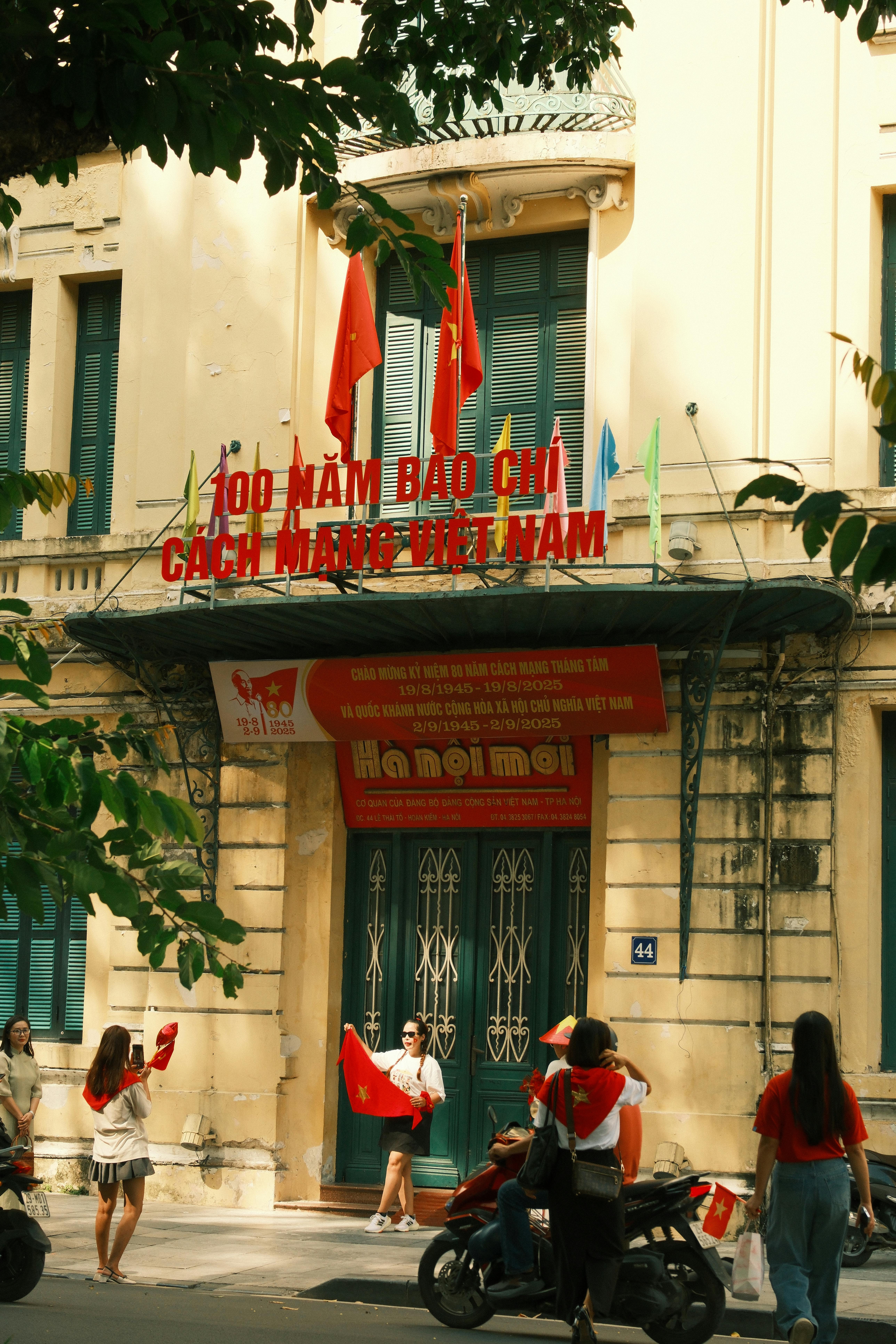 Celebration of 100 years of Vietnamese revolutionary journalism with flag-waving participants.