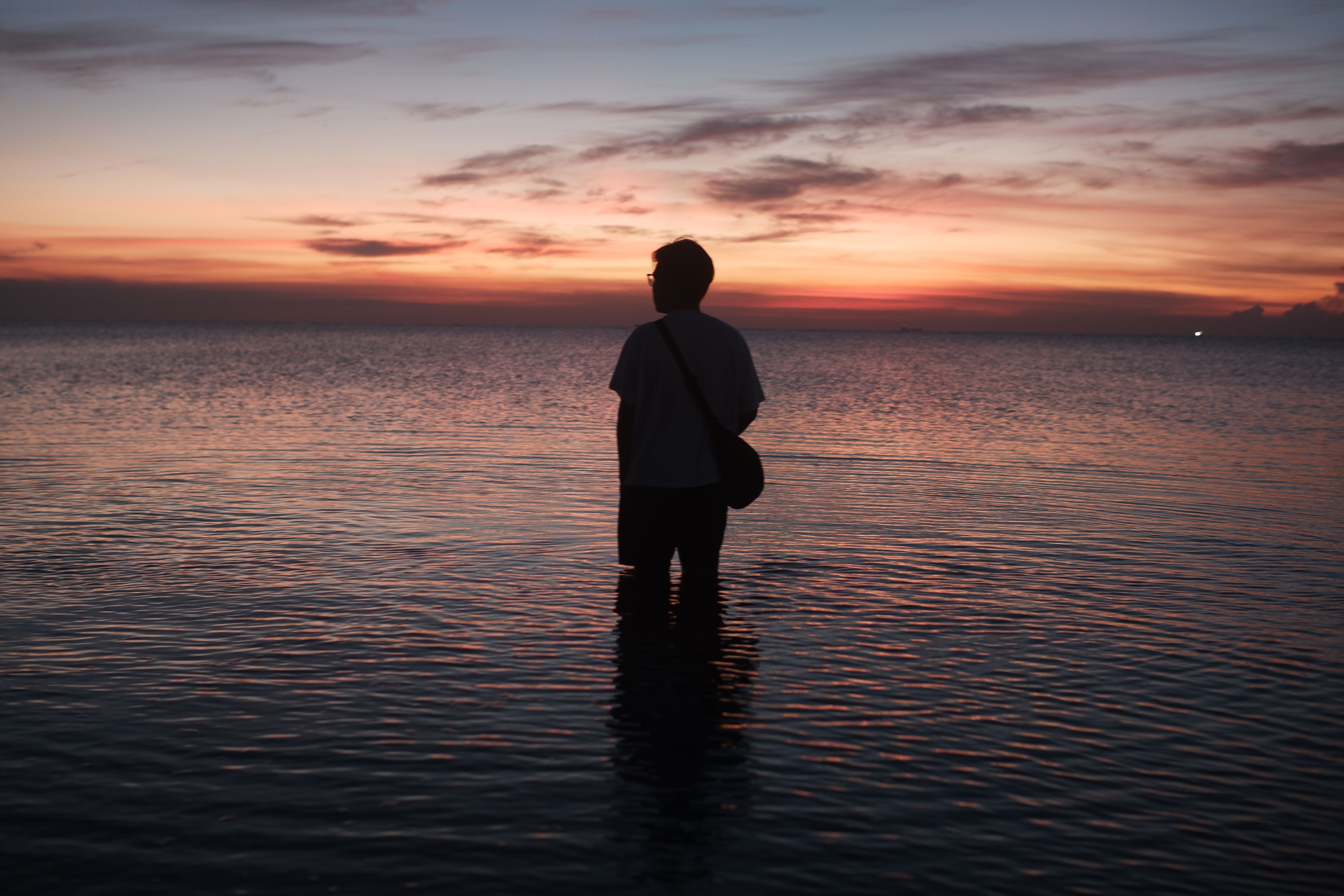 Silhouette of Person in Water During Sunset · Free Stock Photo