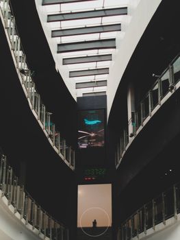 A striking view of a modern building's interior with curved balconies and a central digital display.