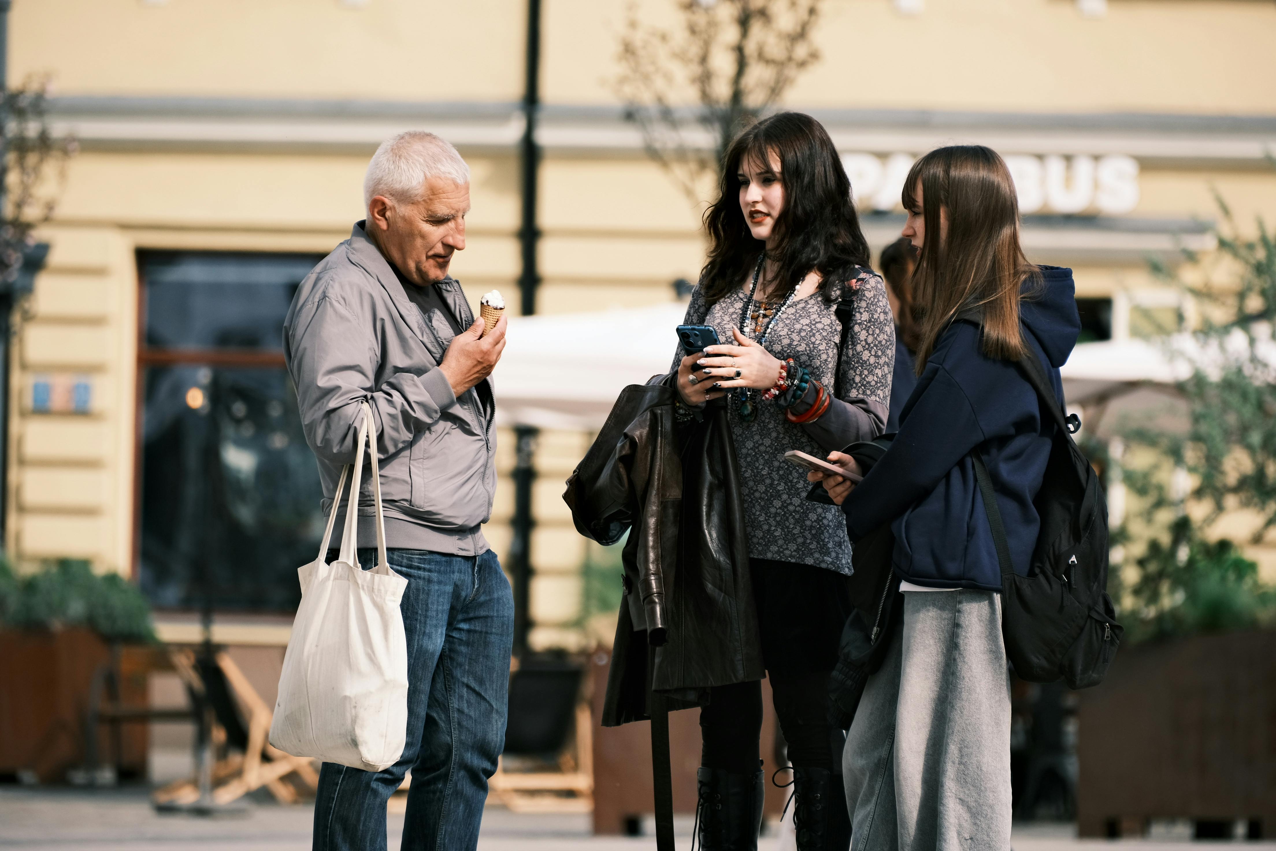 A group of people having a casual conversation outdoors on a sunny day.