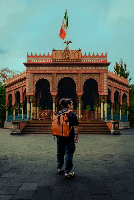 A traveler with a backpack stands in front of the Kiosko Morisco, a colorful historic landmark in Mexico City.