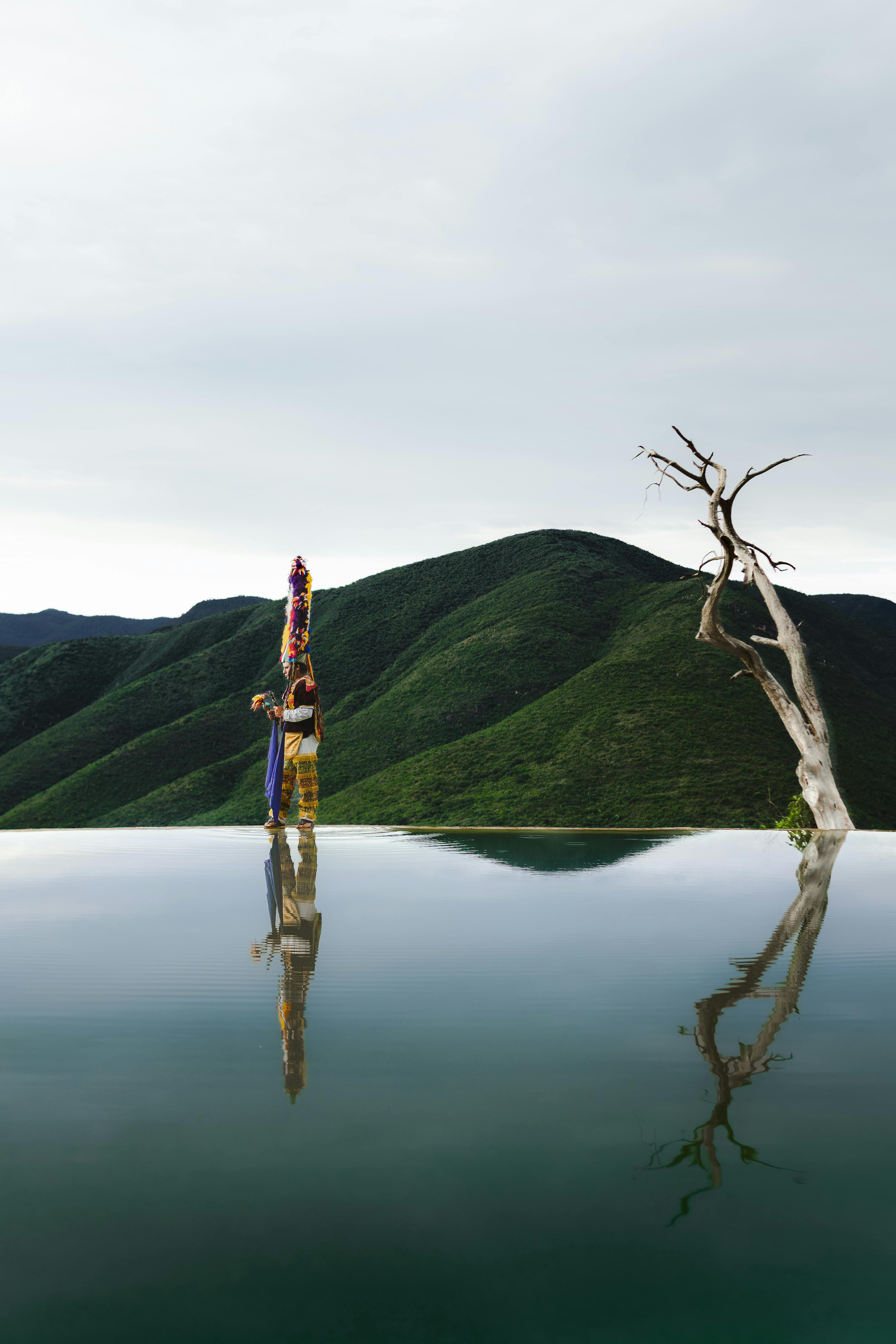 A dancer in traditional attire reflects in the water at Hierve el Agua, Oaxaca, Mexico.