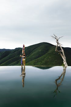 A dancer in traditional attire reflects in the water at Hierve el Agua, Oaxaca, Mexico.