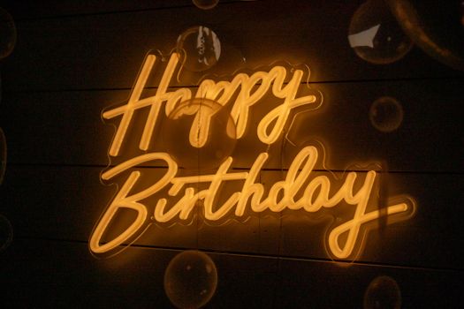 Neon sign with 'Happy Birthday' text and glowing bubbles, perfect for celebrations.