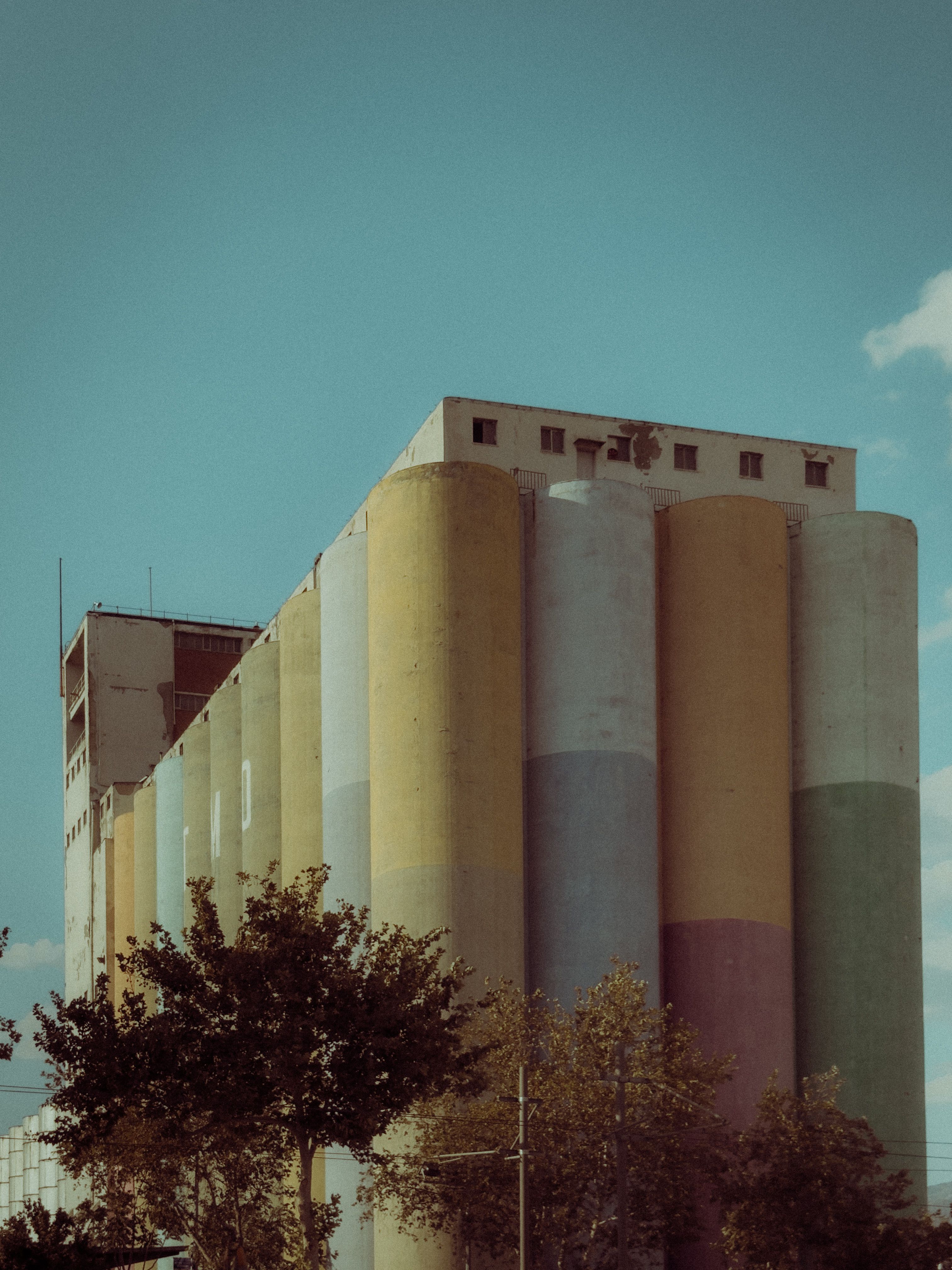 Colorful Industrial Silos against Blue Sky · Free Stock Photo