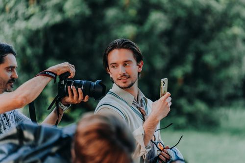 Free Group of photographers engaging in an outdoor shoot under trees. Stock Photo